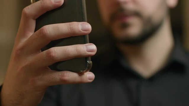 Cropped shot blurry view unknown Caucasian man hand hold phone smartphone gadget browsing mobile internet texting messages business chat use cellphone device businessman customer using telephone app