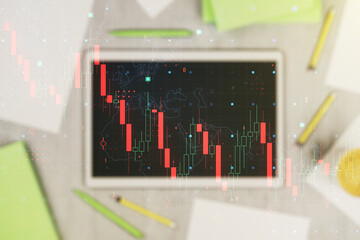 Creative abstract economic crisis chart with world map hologram and modern digital tablet on desktop on background, top view, bankruptcy and recession concept. Multiexposure