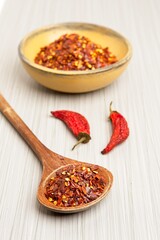 red pepper flakes in a spoon and a bowl.