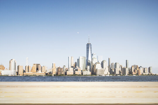 Blank wooden table top with beautiful New York skyline at daytime on background, mockup