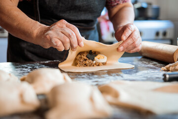 Latin Elderly Woman Making Chilean Baked Empanadas in the Authentic Ambience of her Countryside Home Kitchen. Close up