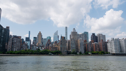 View of Manhattan midtown across the East River with billionaire's row skyscrapers visible in the background.