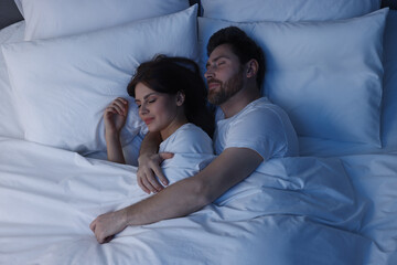 Fototapeta na wymiar Lovely couple sleeping together in bed at night