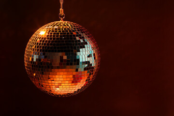 Shiny bright disco ball on dark background, space for text