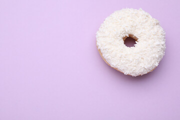 Tasty donut with coconut shavings on purple background, top view. Space for text