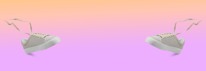Pair of stylish sneakers in air on color gradient background. Banner design with space for text