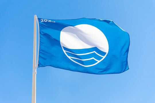 "Islantilla, Huelva-Spain"; 07-29-2023: Blue flag waving. International award for quality, safety, services and the environment of beaches.
