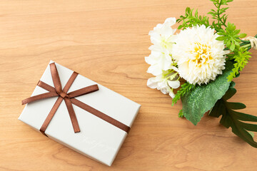木目背景に花束とプレゼントボックス