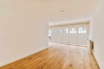 an empty room with white walls and wood flooring in the middle of the room, there is a heater on the wall