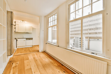 an empty living room with wood flooring and white walls in the room is very large, bright window view