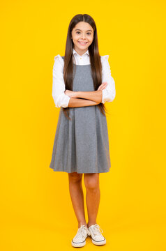 School uniform. Full length of her she attractive pretty lovely cute cheerful cheery teenager child girl isolated over vivid yellow background.
