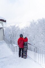 Portrait of Asian woman practice snowboarding on snow mountain at ski resort. Attractive girl enjoy...