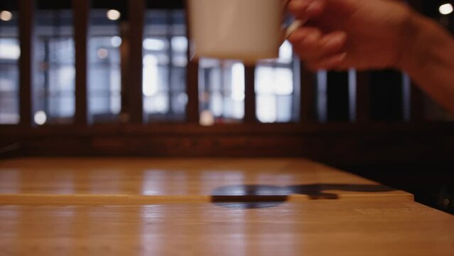 スロー映像：テーブルにコップを置く手元