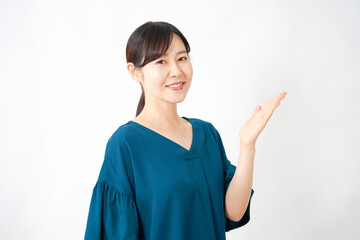 手のひらで右側を指すミドルエイジの女性　白背景
