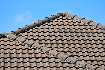 grey roof tile of house on blue sky and white cloud background