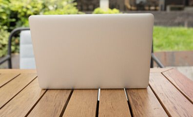 Laptop and nature. Modern laptop on a wooden table. Close-up. 