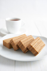 traditional indonesian kek lapis (layered cake) and a cup of coffee isolated on white background