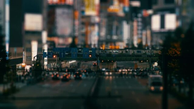 Dramatic landscape of trains and cars go through between high buildings at night, Shinjuku in Tokyo, Blurred, Business or finance