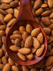 Dried almonds. Almond kernels lie in wooden spoon. Top view of nuts close-up. Advertising photography for marketplaces or online stores.