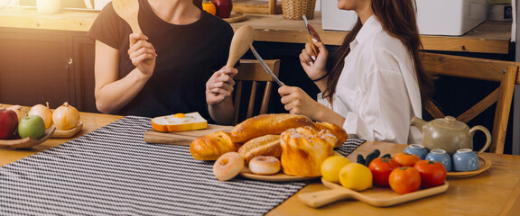 Laughing group of diverse young woman hanging out at home together and eating pizza