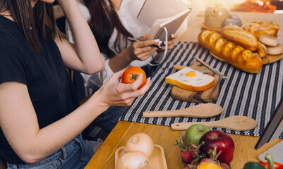 Laughing group of diverse young woman hanging out at home together and eating pizza
