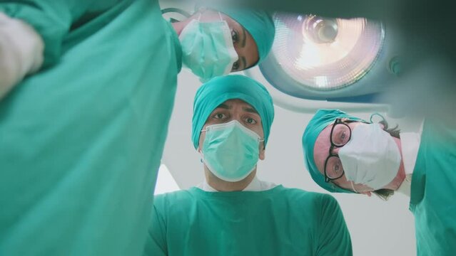 Specialist surgeons and assistant practitioners team discuss and analyze with professional doctor for surgery operations on critically ill patients in hospital's ICU, and paramedic treatment.