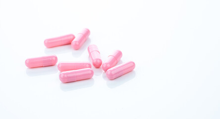 Pink capsule pills on white background. Pharmaceutical industry. Vitamins, minerals, and supplements concept. Pharmacy products. Pharmaceutical medicine. Prescription drugs. Healthcare and medicine.