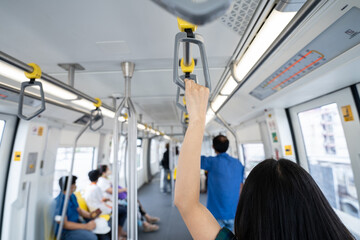 Woman hand firm grip safety handrail in elevated monorail train. Mass transit system in modern...
