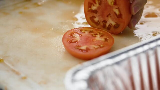 Slow motion, close up on a round slice of a tomato.