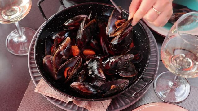 Portion of steamed mussels served on plate with piece of lemon. Spanish dish mejillon al vapor. High quality 4k footage