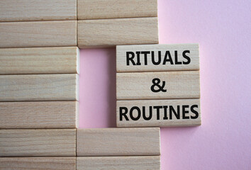 Rituals and Routines symbol. Concept words Rituals and Routines on wooden blocks. Beautiful pink...