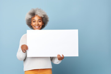 Happy mature senior black woman holding blank white banner sign, isolated studio portrait.