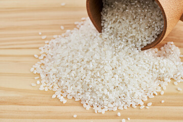 Asian short grain rice in wood scoop on wooden table background. Asian short grain rice food...