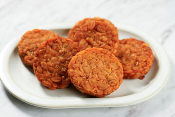 Tempe Goreng or Fried Tempeh on White Plate. T