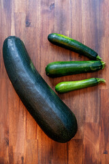 Big and small zucchinis. Fresh zucchini on wooden background.