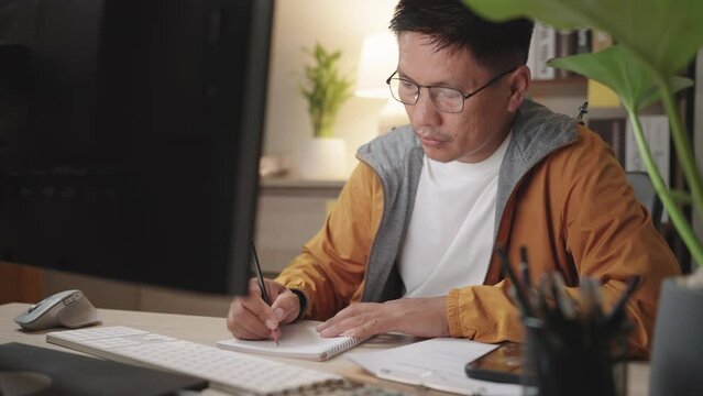 close-up of asian Businessman online video conference and meeting via computer at night in home, online education, studying concept,Online internet marketing, freelance, working from home.