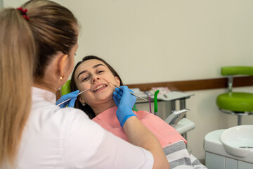 woman at a dentist's appointment checks her teeth and gums, caries prevention