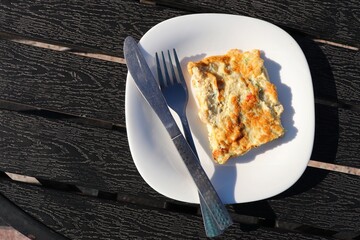 Masala Egg omelette, omelet with tomatoes, onion, and green chili on dark wooden background with copy space. Healthy diet food for breakfast. Tasty morning food. Top view, flat lay.