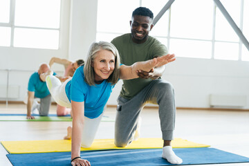 African American man helps mature lady athlete with posture