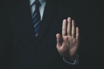 male hand showing stop gesture Concept of stop violence. Warning, prohibition, denial. On dark...