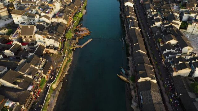 Drone shot tilting over the Tuo Jiang river and the Phoenix Hong Bridge, in sunny Fenghuang County, China