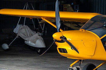 Detail of the propellers of a yellow plane inside the hangar.