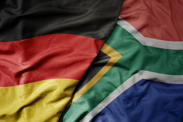 big waving realistic national colorful flag of germany and national flag of south africa .