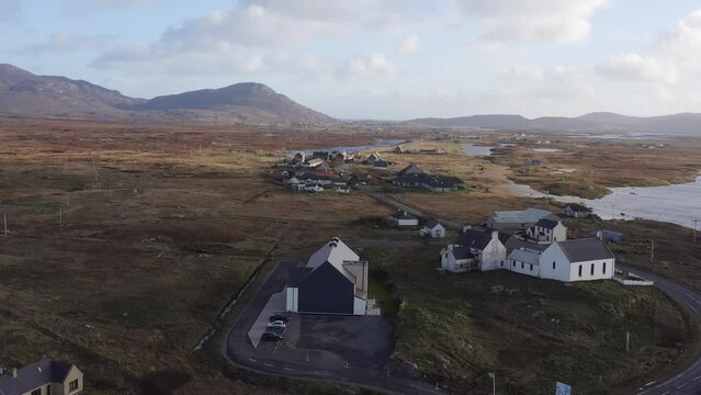 Spinning drone shot circumnavigating the Cnoc Soiller building in Daliburgh, South Uist. Shot on the Outer Hebrides of Scotland.