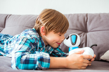Cute boy playing with interactive toy. Child with toy robot dog. Activities for small children. Communication and digital concept