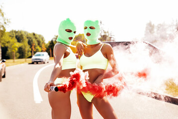 Two beautiful sexy women in green underwear. Models wearing bandit balaclava mask. Hot seductive...