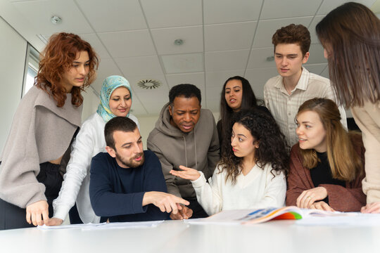 Students having discussion with book in classroom