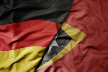 big waving realistic national colorful flag of germany and national flag of east timor .