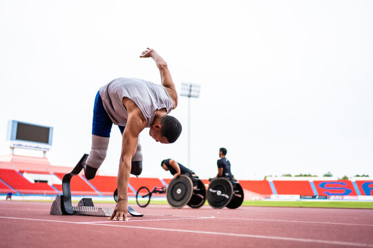 Asian para-athletes disabled with prosthetic blades running at stadium.  - Powered by Adobe