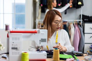 Diverse women fashion designer work design clothes in tailoring atelier. 